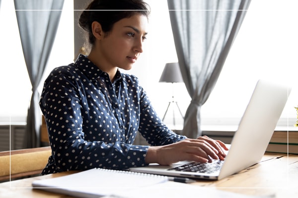 Student sitting at desk, working on laptop