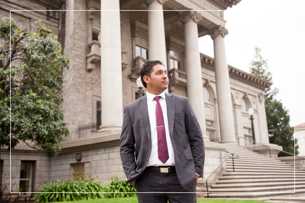 Faculty member in suit standing outside campus building