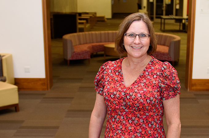 Cindy Tengler stands on the stairs leading to the library foyer.