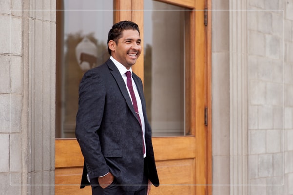 Man in a suit standing outside a campus building