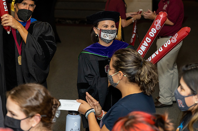 President Newkirk celebrates students as they walk into the Memorial Chapel.