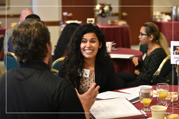 Man and woman speaking at an event table