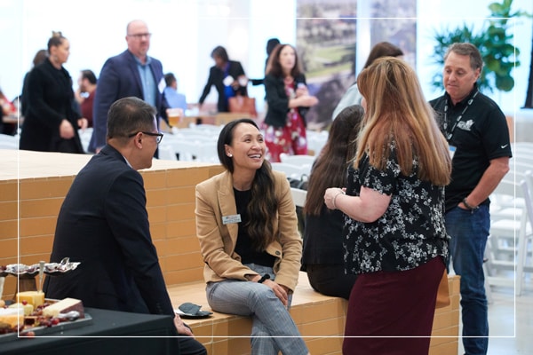 A group of presenters talking and laughing with one another