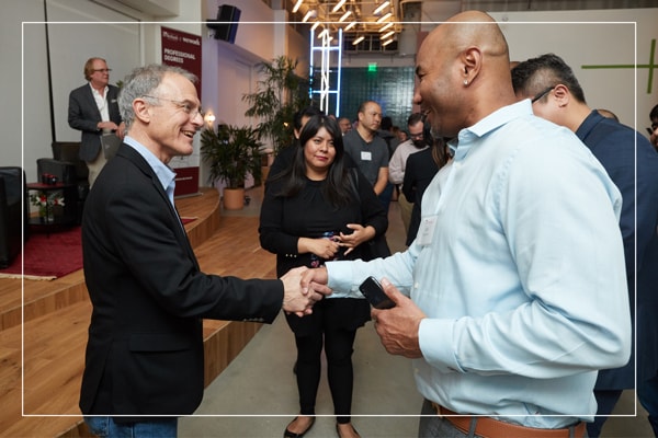 Two men in formal wear shaking hands