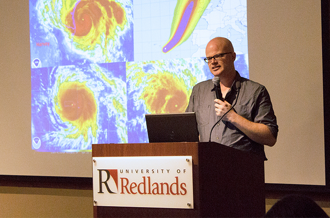 Dr. Andrew Schroeder, speaking into the microphone about his research. 