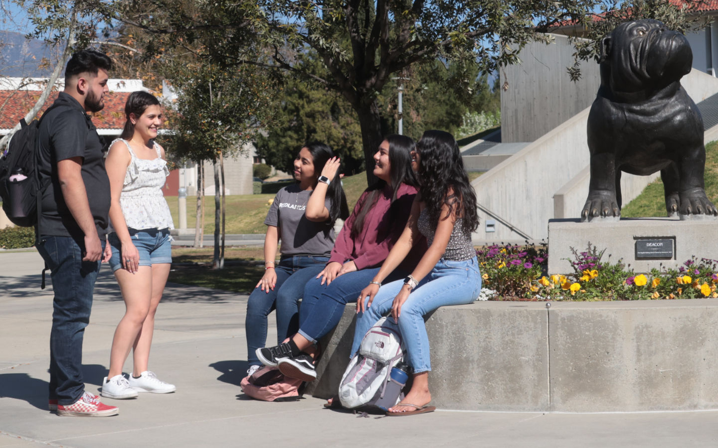 students talking near Bulldog statue