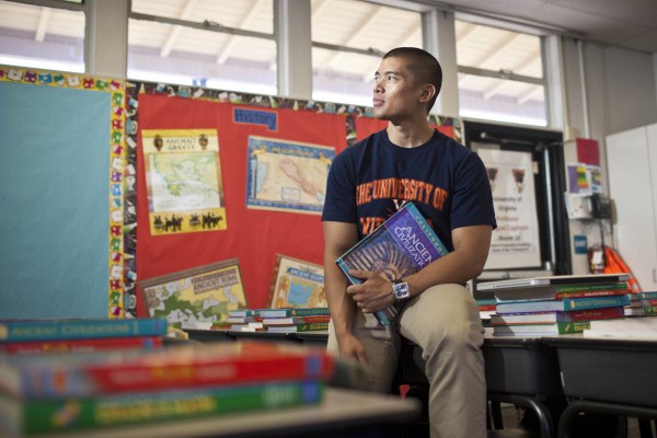 Student looks off in the distance with a history textbook